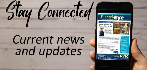 A hand holds a smartphone displaying a digital newsletter. The background reads Stay Connected and Current news and updates in large, stylish text on a wooden surface.