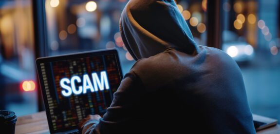Hooded individual committing online fraud