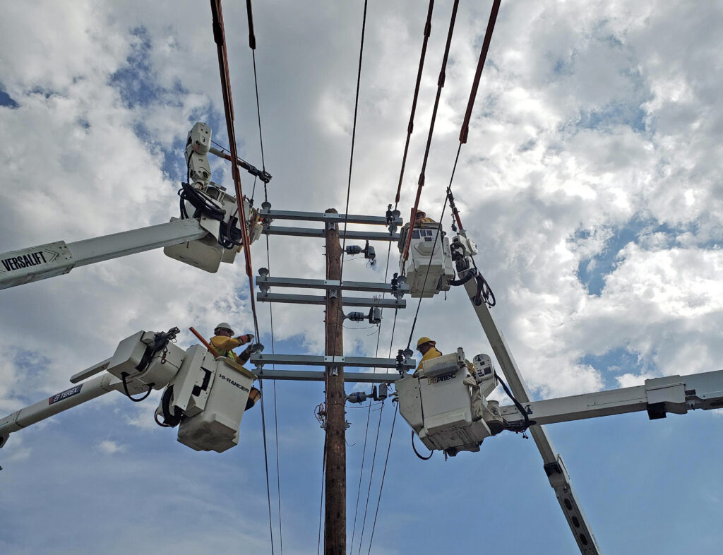 Four utility buckets in the air with a blue cloudy sky.